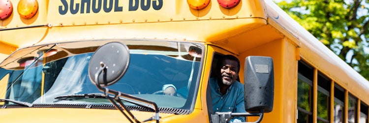 senior school bus driver looking at camera through window