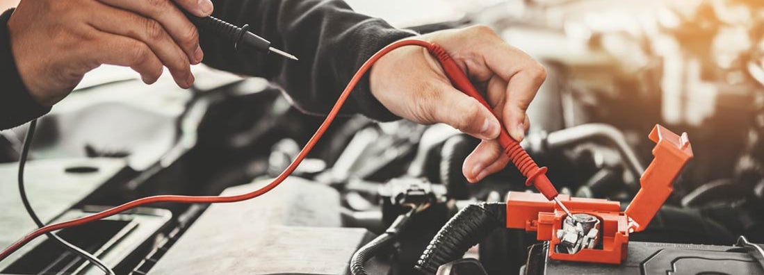 Car mechanic working in auto repair service and maintenance of car battery. Find battery and ignition shop insurance.