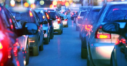 Cars in a city with a traffic jam at night. Find car insurance.