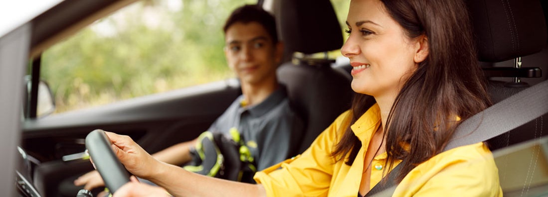 Mother driving her son to the school. Find Austin Texas car insurance.