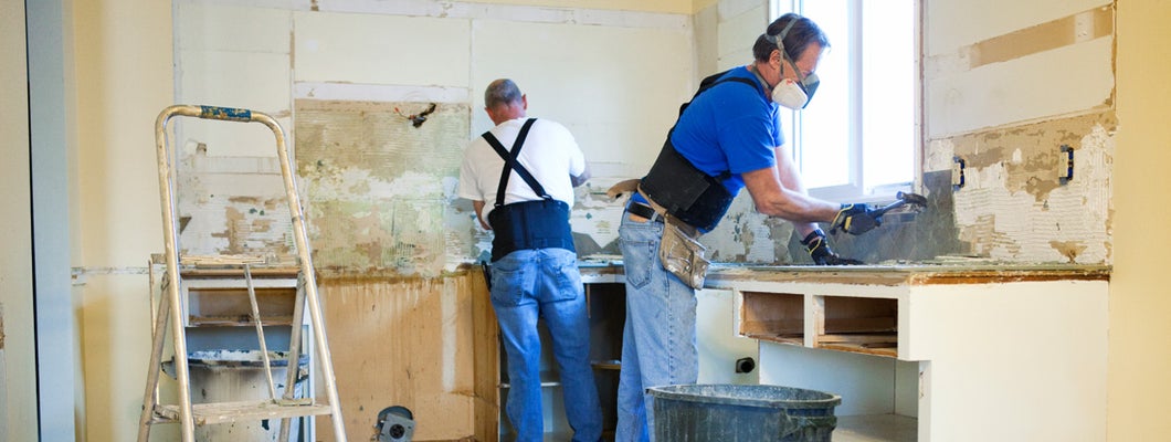 Two men tearing out old kitchen during home renovations