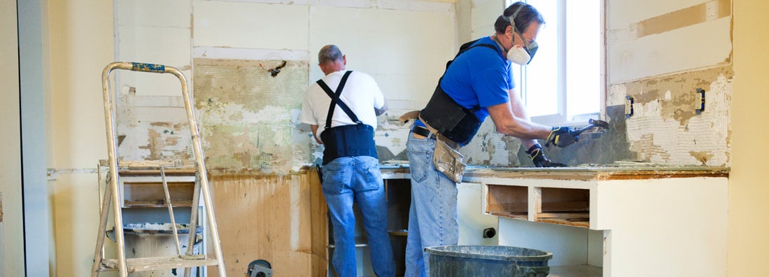 Two men tearing out old kitchen during home renovations