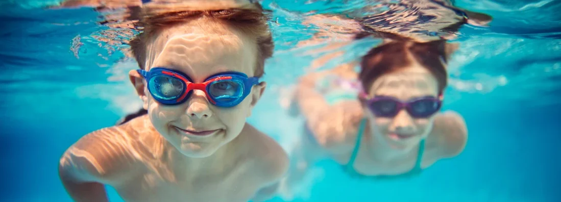 Kids swimming underwater in pool. 6 Fascinating Facts You Might Not Know About Pool Liability.