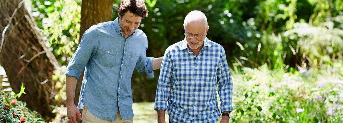Happy senior man and son walking together in park. Find Charlotte North Carolina life insurance.