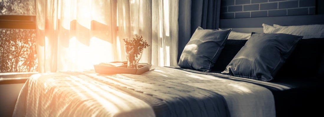 Bed maid-up with clean white pillows and bed sheets in room of bed and breakfast. 