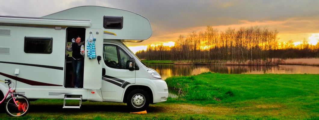 Woman in RV camping at sunset on vacation. Find Georgia RV Insurance.