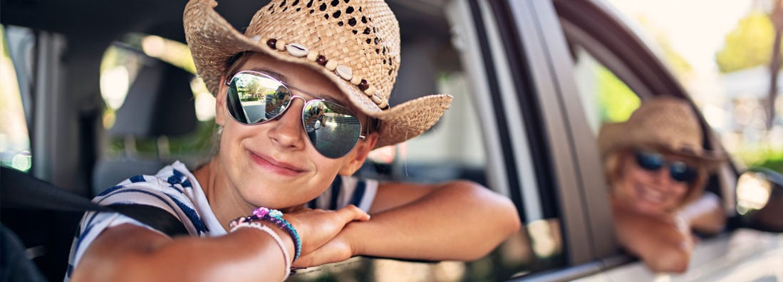 Mother and daughter looking out of family car. Find Lubbock Texas car insurance.