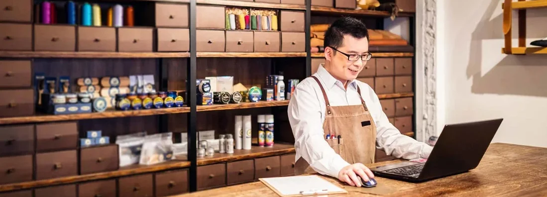 Small business owner filling orders on computer. Find Great Neck, New York business insurance.
