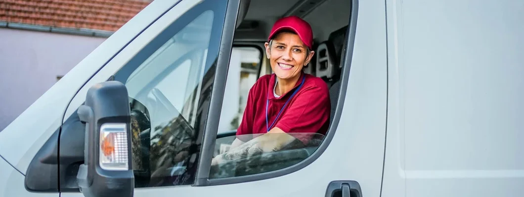 Smiling delivery woman in the van. Find Wisconsin Commercial Vehicle Insurance. 