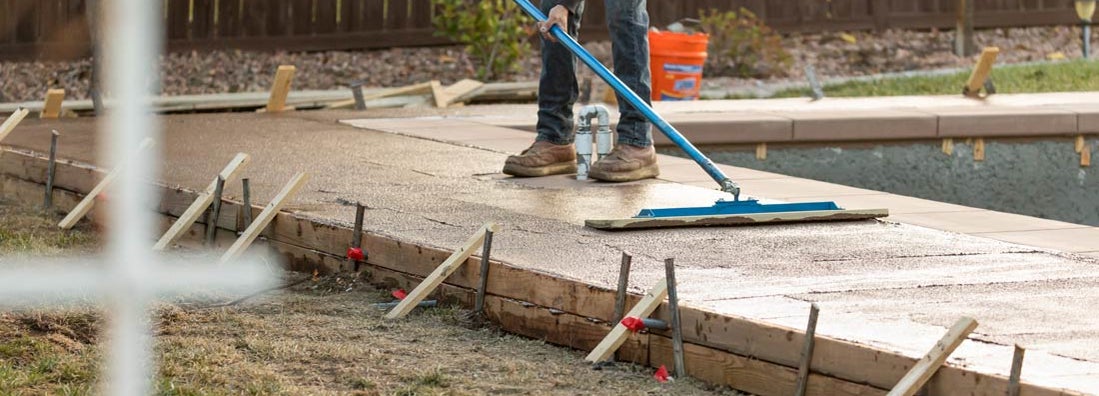 Construction Worker Smoothing Wet Cement With Trowel Tool. Find concrete finishing service insurance.