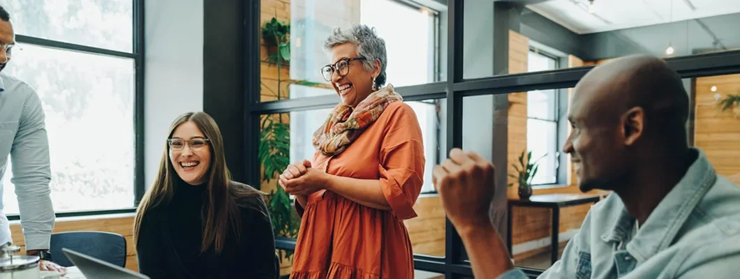 Businesspeople smiling cheerfully during an office meeting. Employee Benefits: A Complete Guide.