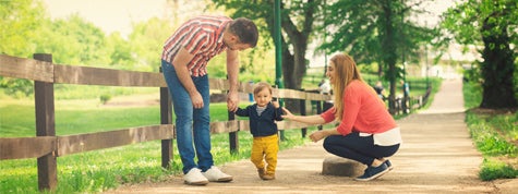 Parents and their baby boy learning to walk