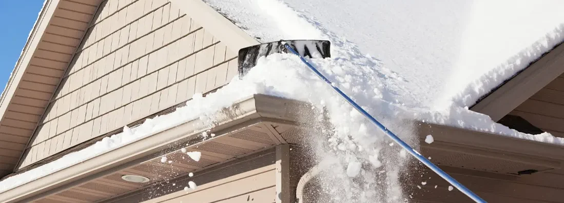 Roof Rake Removing Winter Snow. Is Too Much Snow on Your Roof an Insurance Problem in South Dakota?