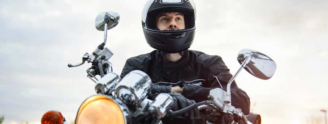 Young man riding his black motorcycle. Florida Motorcycle Insurance.