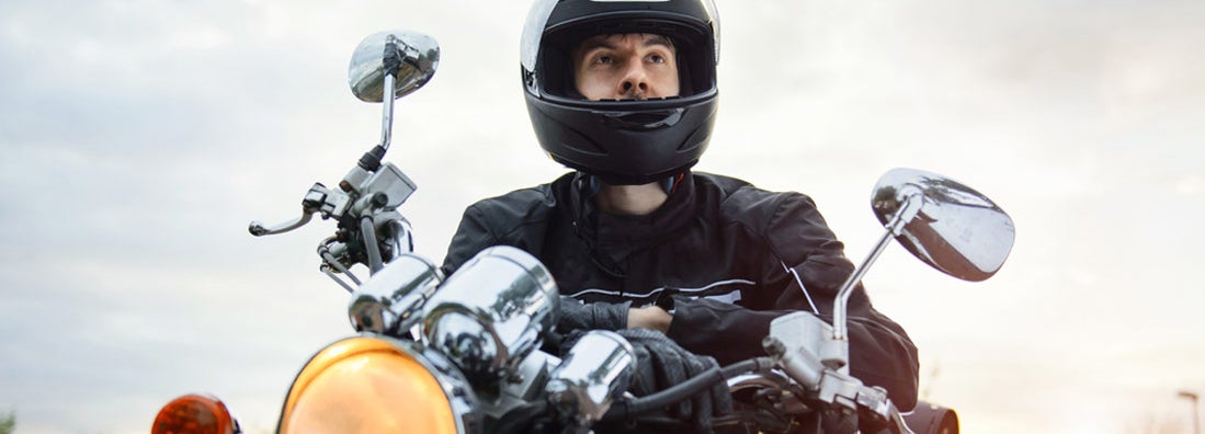 Young man riding his black motorcycle. Florida Motorcycle Insurance.
