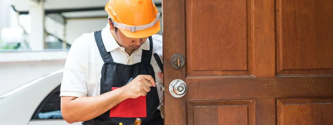 Locksmith repairing old knob on wood door for house. Find Locksmith Insurance.