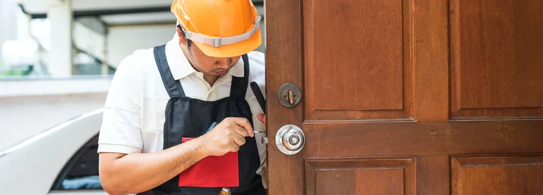 Locksmith repairing old knob on wood door for house. Find Locksmith Insurance.