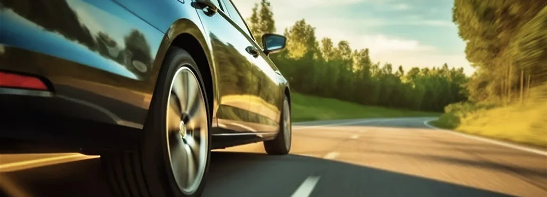 Car rushes along the highway at sunset. Find Cheap Car Insurance.