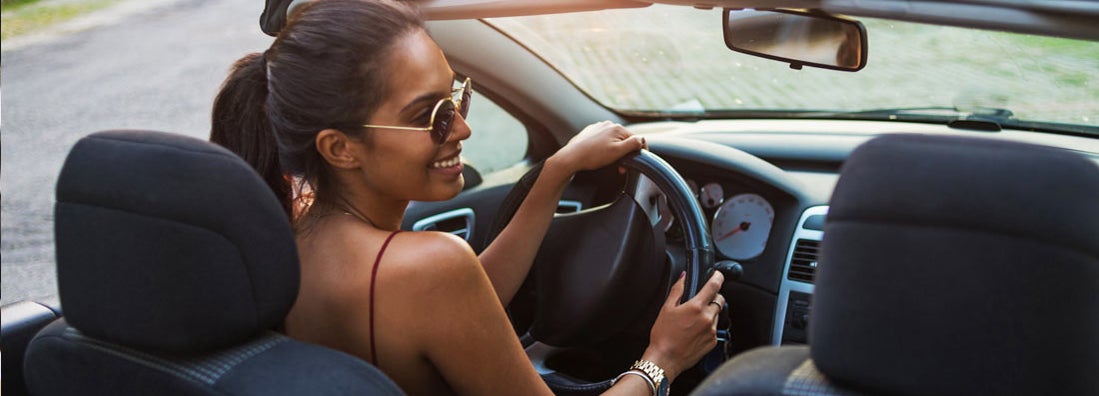 Young woman driving a convertible car. Find Sacramento California car insurance.