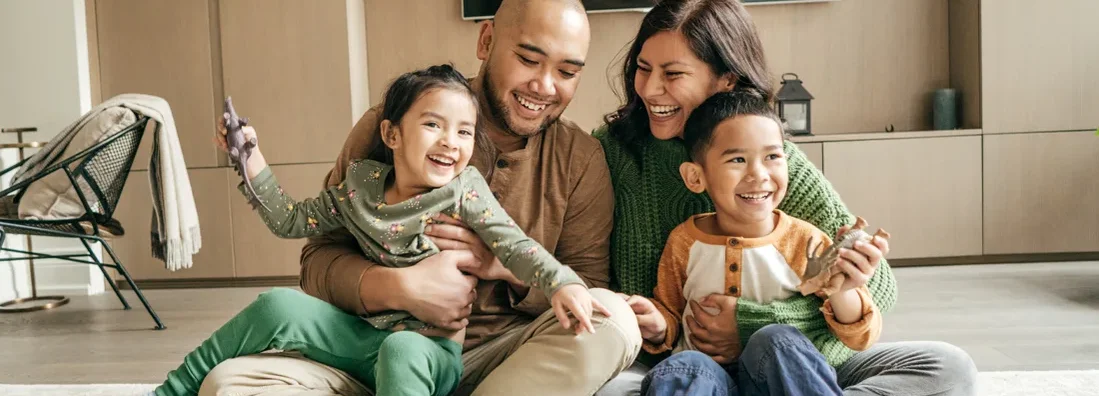 Happy family at home on winter holidays. Find Massachusetts Life Insurance.