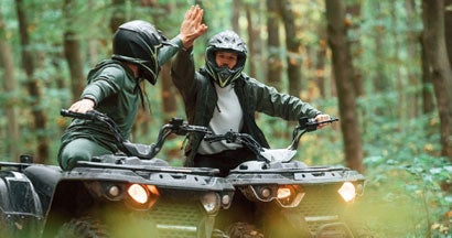 Two ATV Riders in the forest together. Find ATV Liability Insurance.