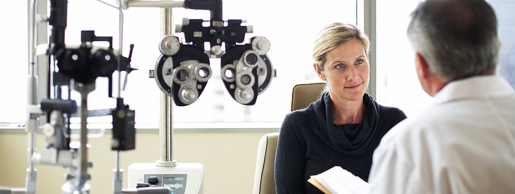 A woman listens to her optometrist. Find optometrist professional liability insurance.