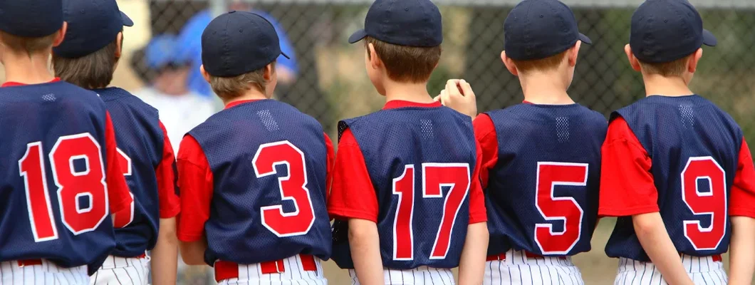 Little League players standing in line before a game. Sports Team Insurance for Youth Leagues: Find Coverage Today.