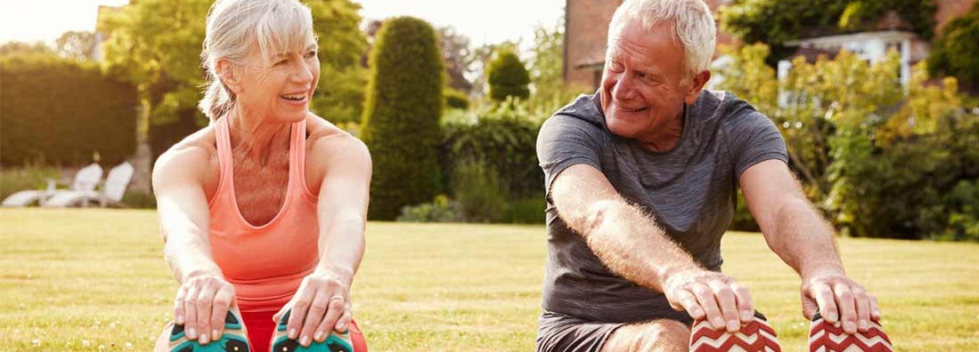 Fit mature couple stretching on the grass. Find Permanent Life Insurance.