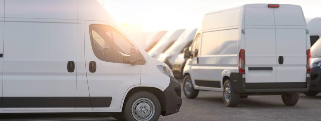 Delivery vans in a row in the rays of sunset or dawn. Find Maine Commercial Vehicle Insurance.