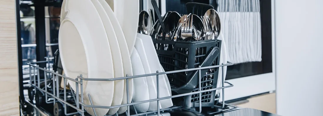 Open dishwasher with clean glasses and dishes close-up. If My Dishwasher Leaks and Floods My Massachusetts Home, Who Pays for the Damage? 
