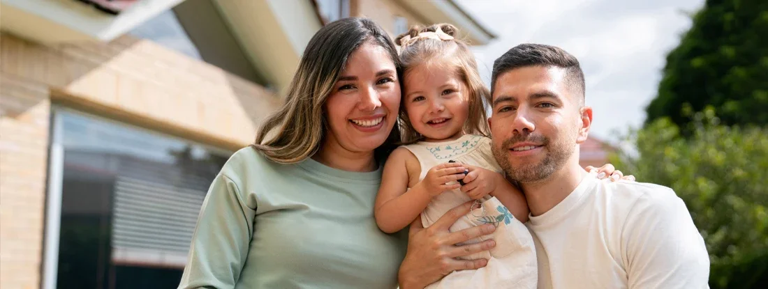 Family outside their house. Buying a House Without a Realtor: Pros and Cons.