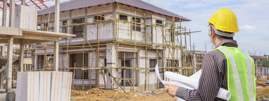 New home construction site with contractor in foreground. Find General Contractor Insurance.