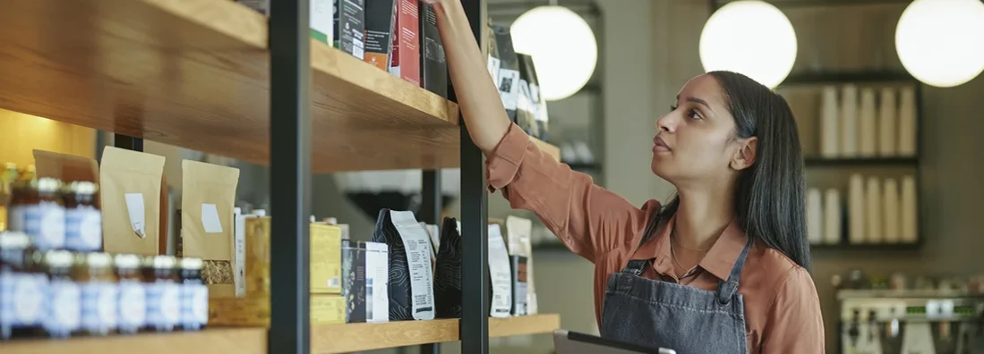 Deli owner using a tablet to check stock in her store. Business Insurance in Farmington, Utah.
