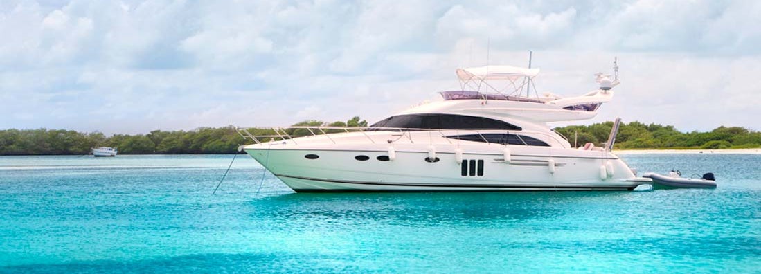 Luxury Yacht anchored in a tropical exotic island beach. Find Yacht Insurance.