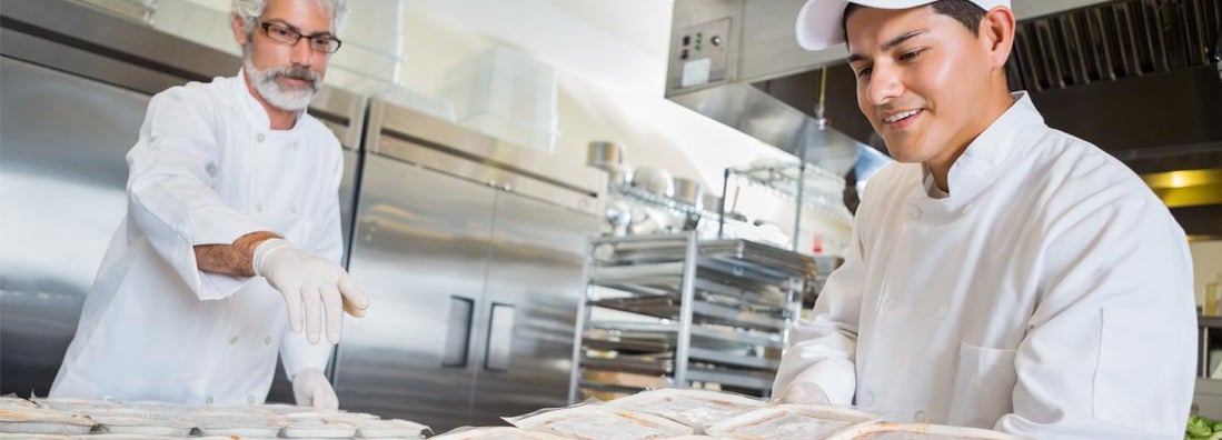 Chefs preparing frozen meals for distribution. Find frozen food seller insurance.
