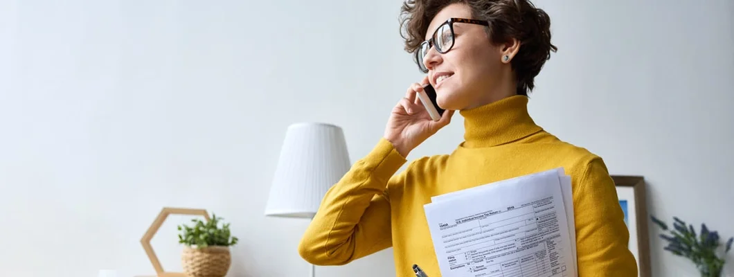 Modern woman with tax and insurance escrow forms talking on phone. Pay home insurance through escrow.