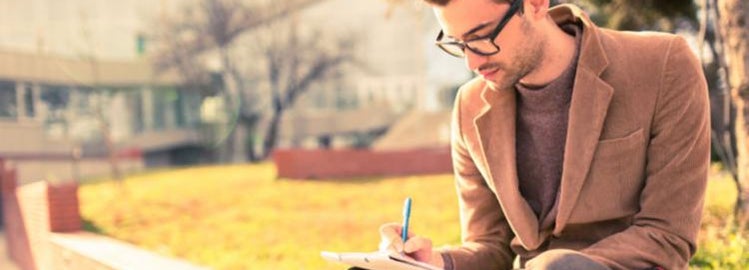 Male college student filling out scholarship applications