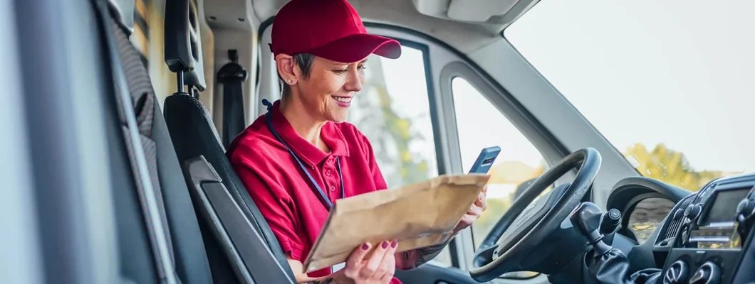 Female courier checking address label. Find Kansas Commercial Vehicle Insurance.