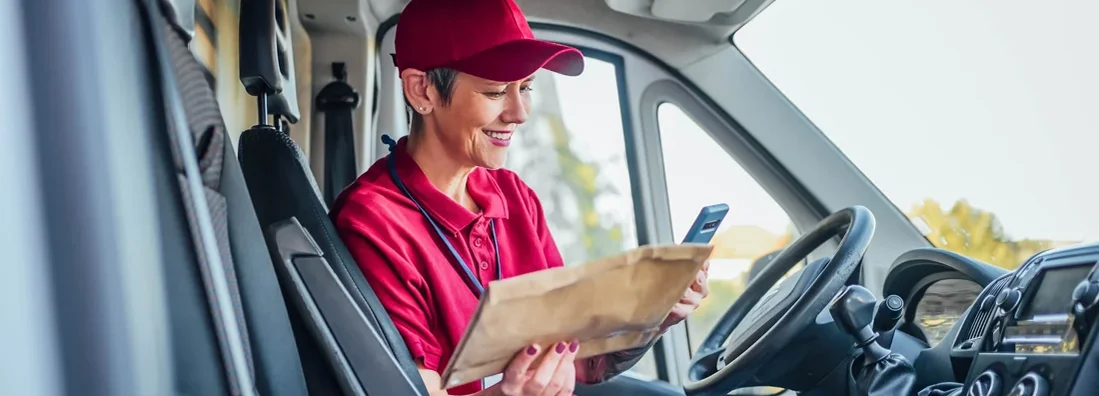 Female courier checking address label. Find Kansas Commercial Vehicle Insurance.