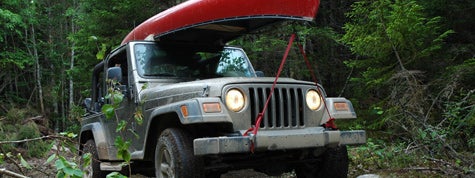 Traveling by Jeep 4x4 through a rough trail in the woods