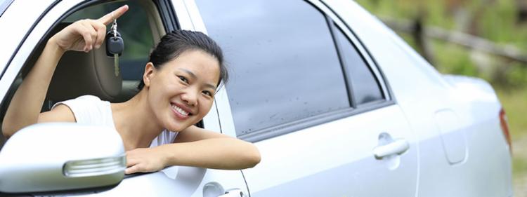 Woman holding keys to her new car.