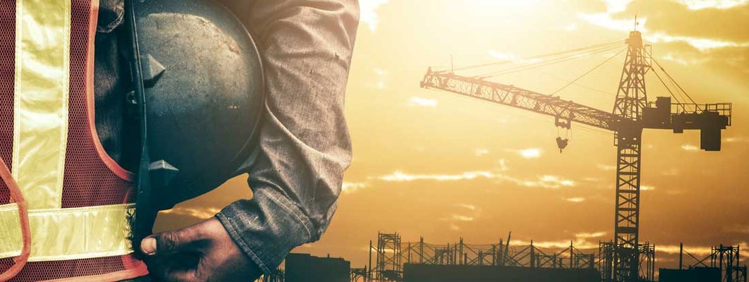 Construction Worker Overlooking Building Site. Find Crane Insurance.