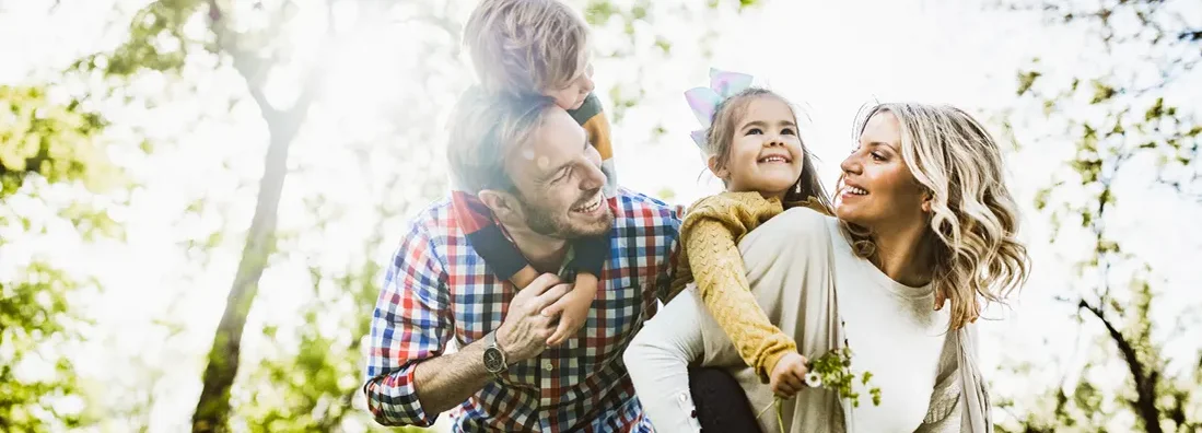 Happy parents having fun with their small kids in nature. Find Illinois Life Insurance.