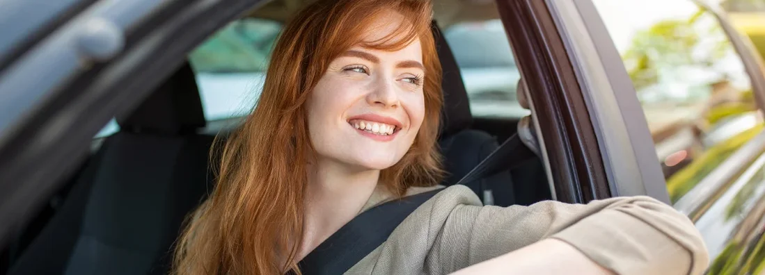 Woman driving her new car at sunset. How to Find the Best Car Insurance in Augusta, Maine. 