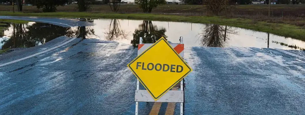 Flooded warning sign on an impassable road. Find West Virginia Flood Insurance.