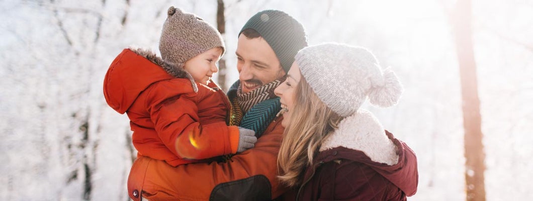 young family, being playful outdoors in nature covered in snow