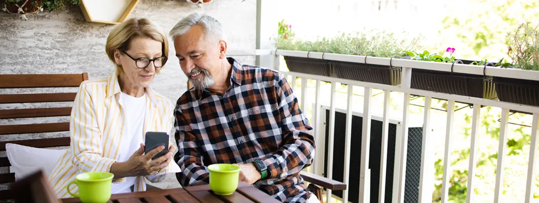 Senior couple enjoying coffee on the balcony. Best Life Insurance Companies for Seniors.