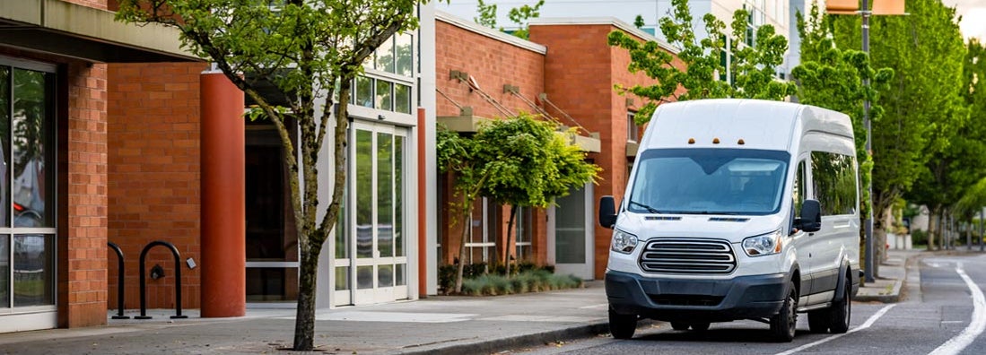 Compact delivery van for small business on urban city street. Find commercial auto insurance.