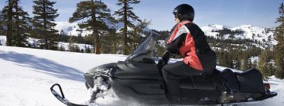 Safe snowmobile rider in the forest