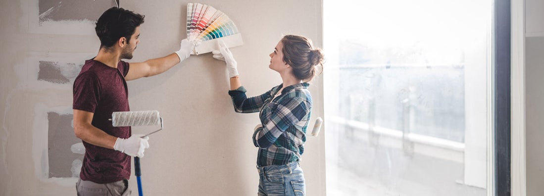 Young couple choosing the right color for their wall in new home. 6 diy home renovation projects that impact your insurance.